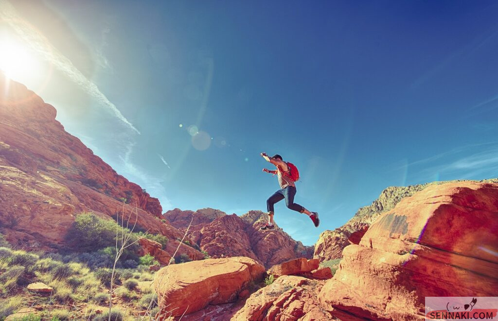 荒野でチャレンジングなジャンプをしている男性の画像